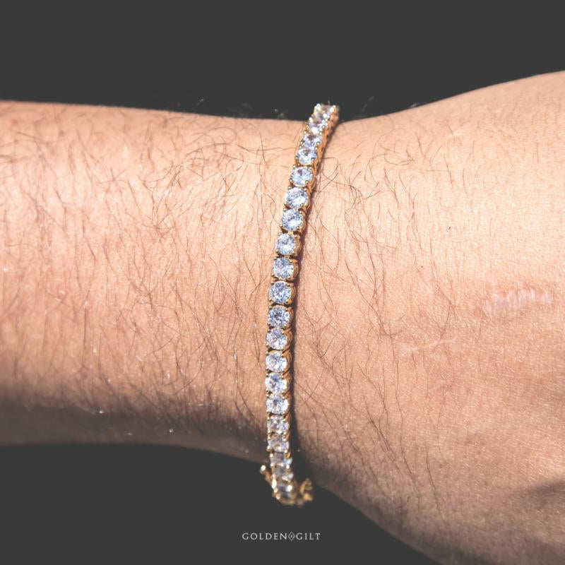 Person wearing a gold tennis bracelet on a wrist