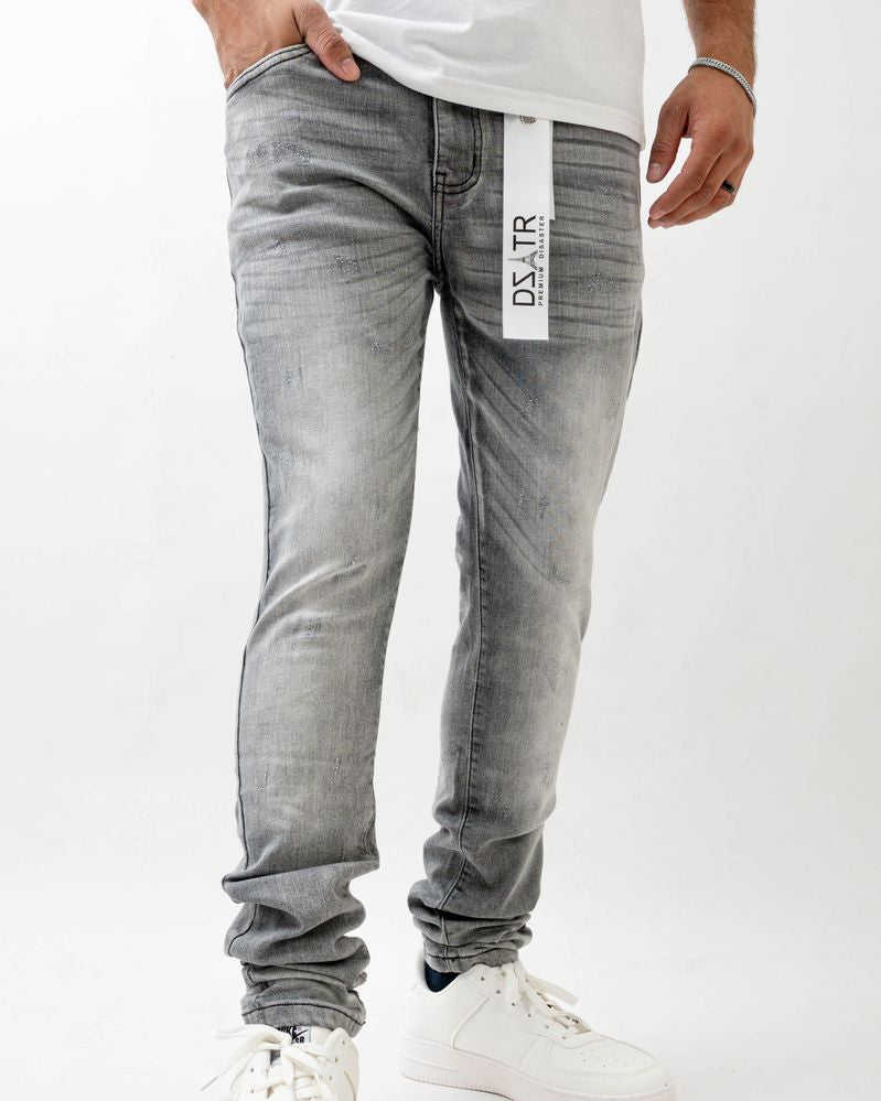 Person wearing gray jeans with a visible brand label on a white background