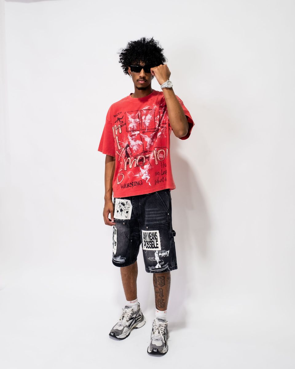 Person wearing a red graphic t-shirt and black shorts with white text on a white background