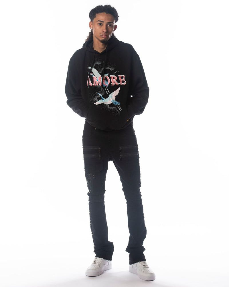 Person wearing a black hoodie with text and graphics on a white background