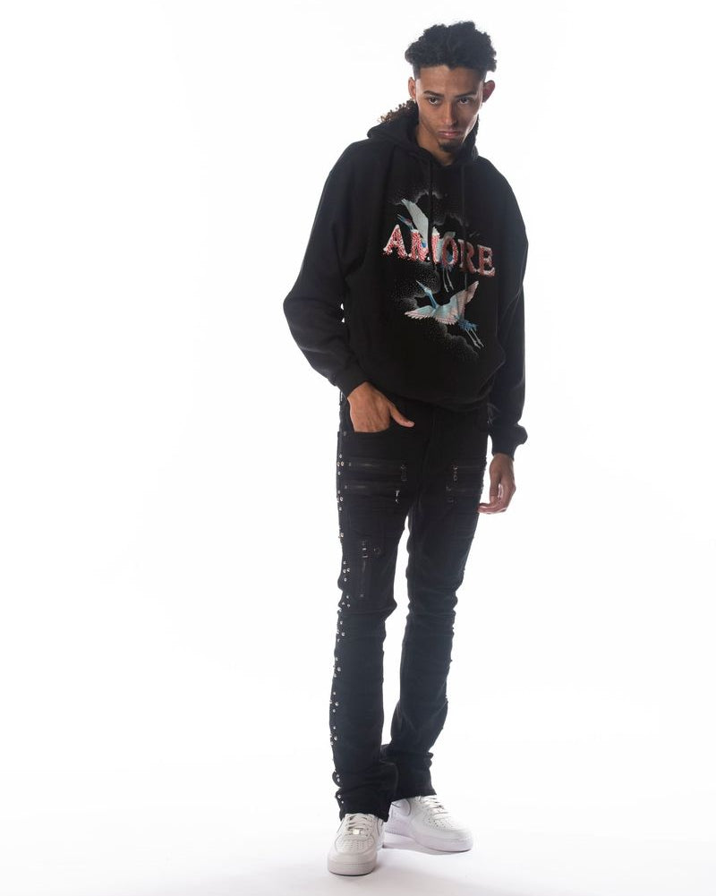 Person wearing a black hoodie with colorful text and graphics, standing against a white background