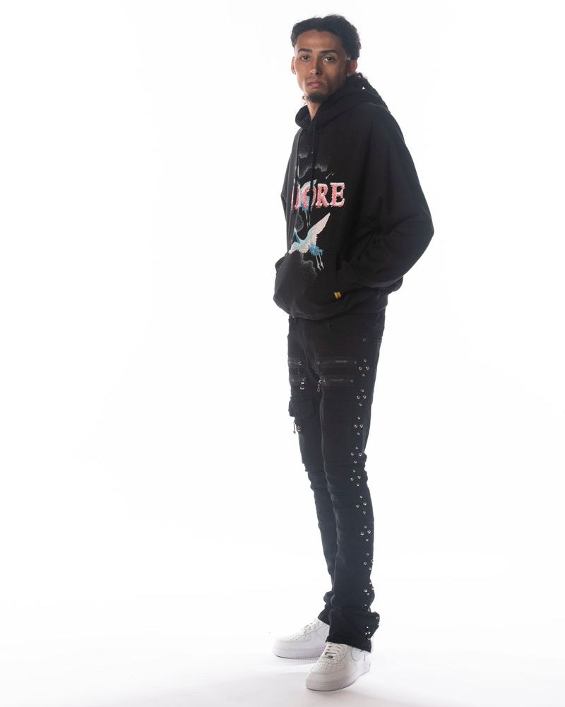 Person wearing a black hoodie with text and graphics on a white background