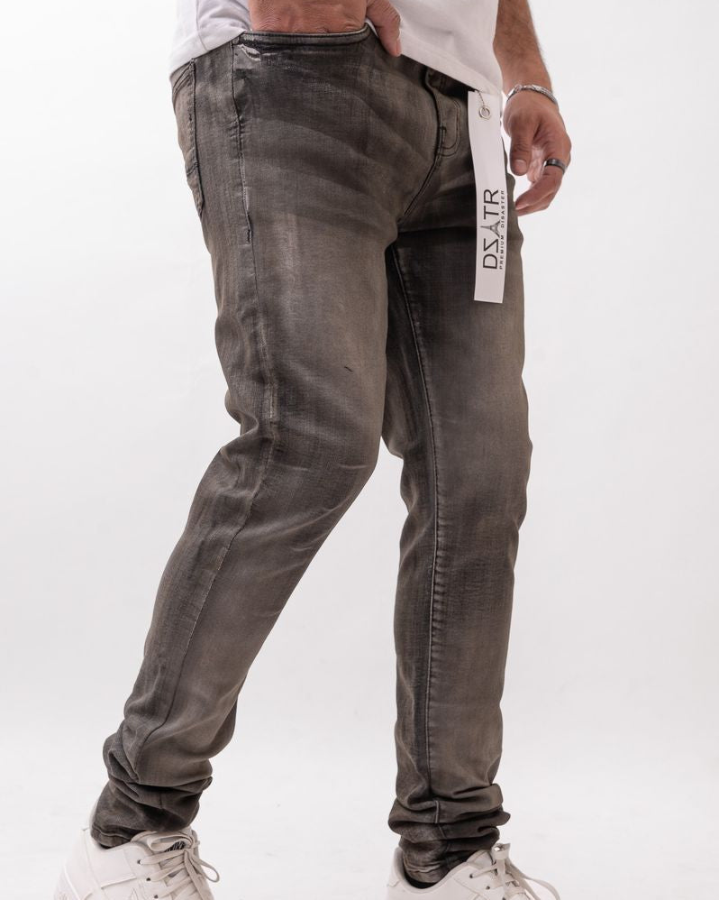 Person wearing gray jeans and white sneakers on a white background