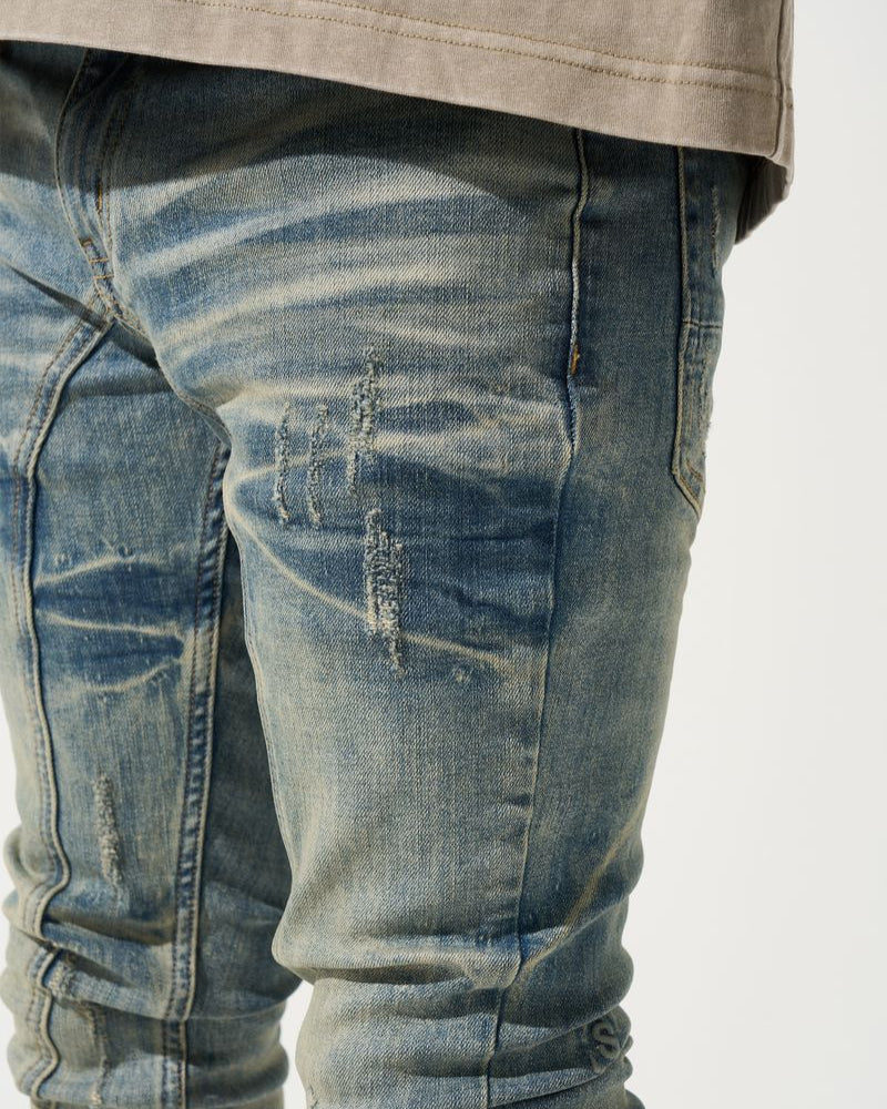 Close-up of distressed blue jeans on a white background