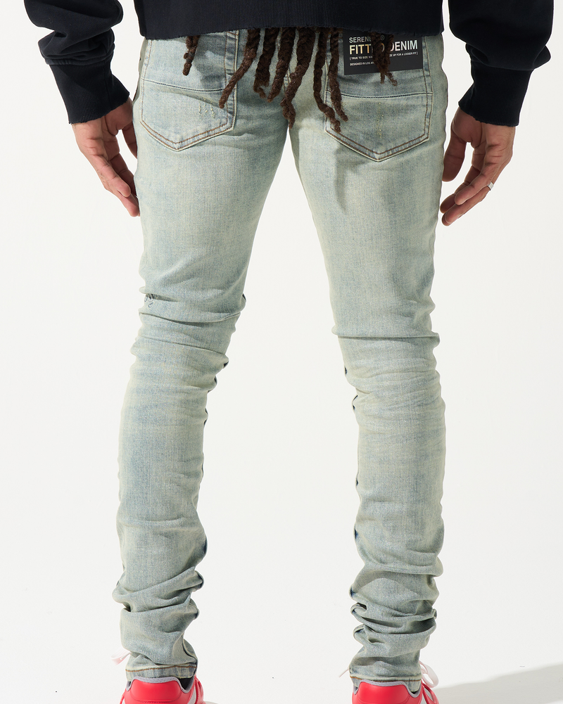 Person wearing light blue jeans and red shoes on a white background