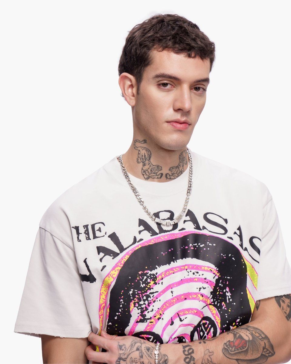 Man wearing a white t-shirt with a colorful graphic design on a plain background