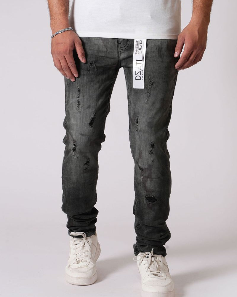 Person wearing black distressed jeans with a white label on a white background