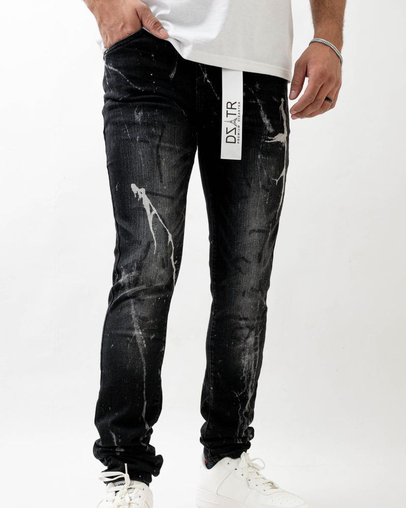 Person wearing black distressed jeans with a visible brand label on a white background