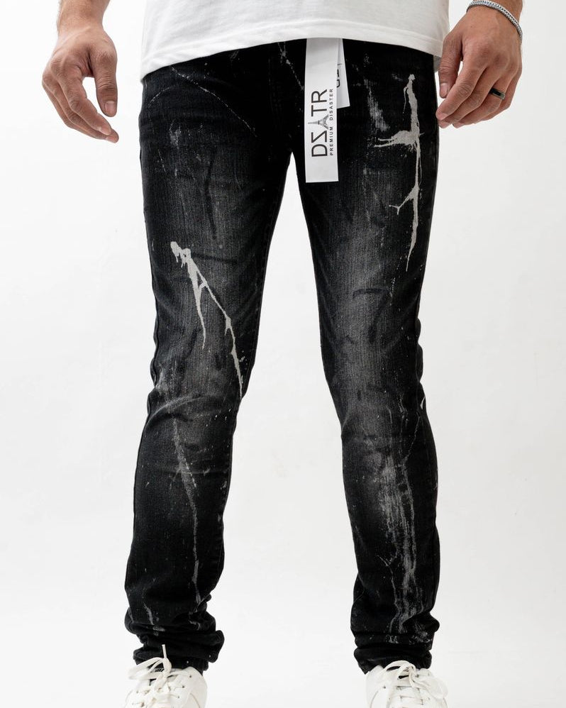 Person wearing black distressed jeans with a visible brand label on a white background