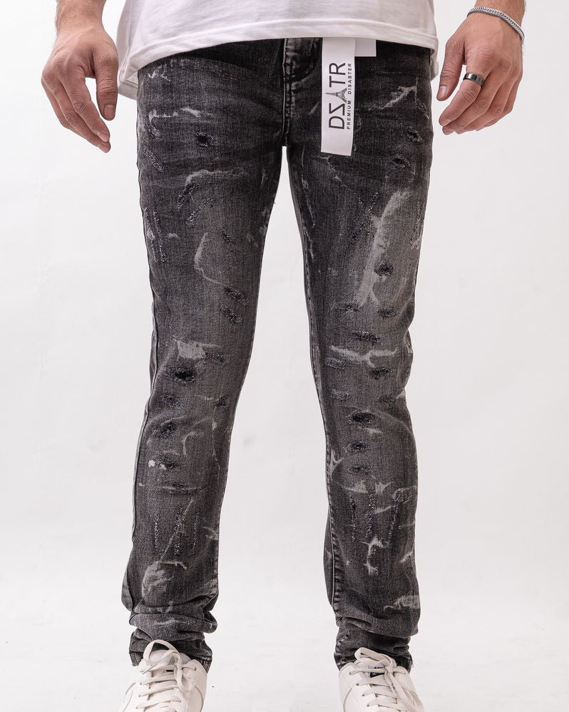 Person wearing black distressed jeans with a visible brand label on a white background