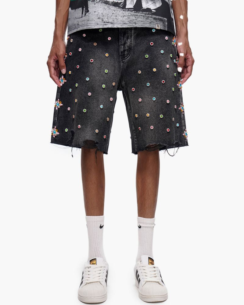 Person wearing black denim shorts with colorful dot pattern on a white background