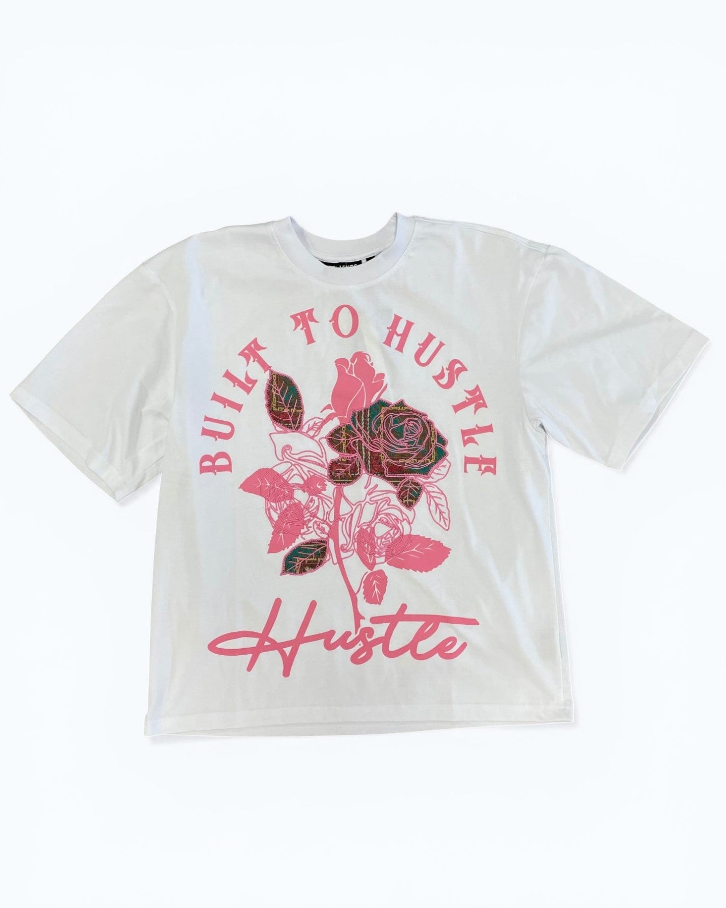 White t-shirt with pink floral design and 'Built to Hustle' text on a white background