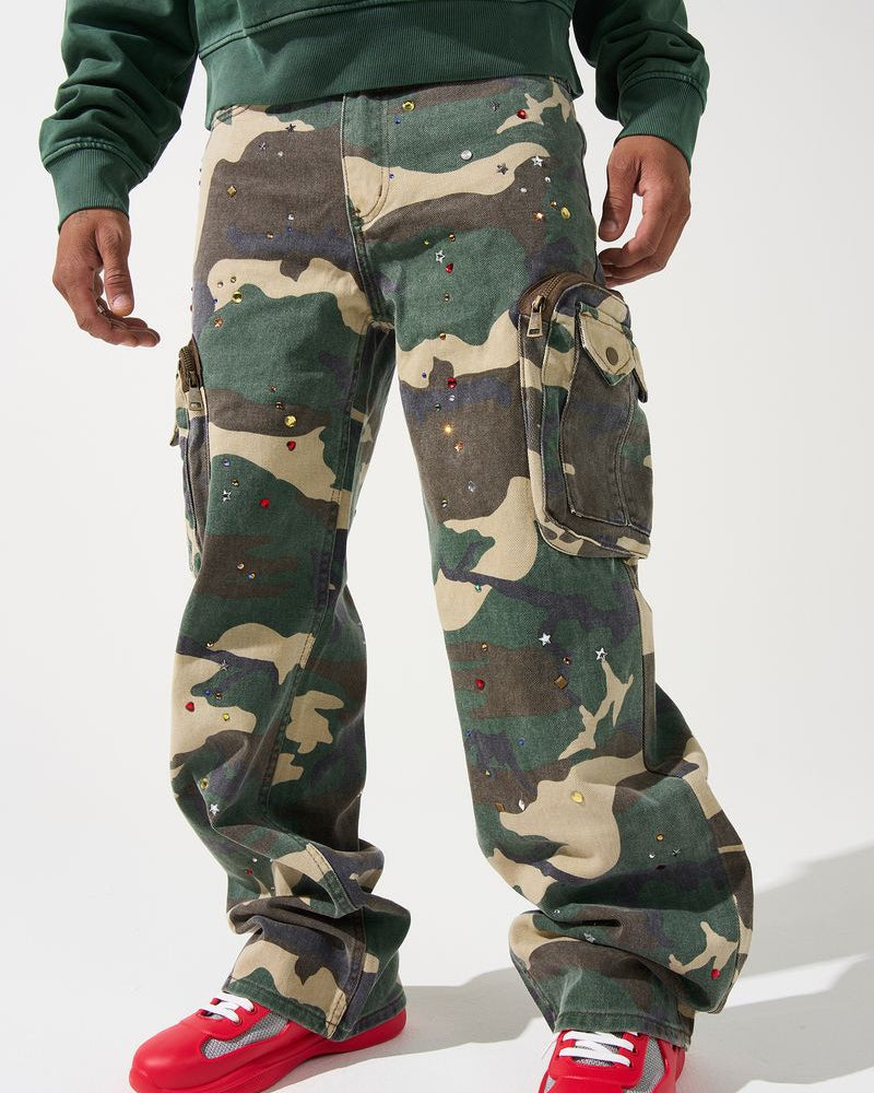 Person wearing camouflage pants and red sneakers on a white background