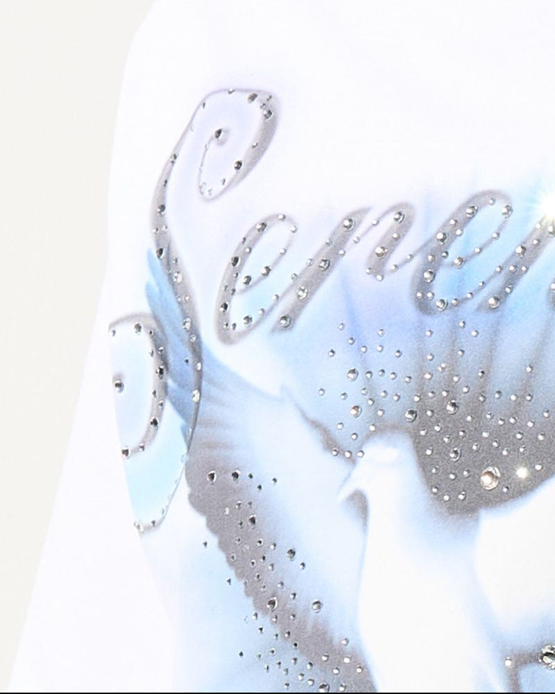 Close-up of a white garment with decorative text and embellishments on a light background