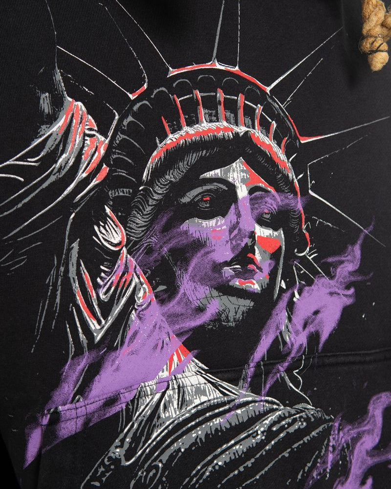 Black hoodie with a stylized depiction of a head wearing a headdress on a dark background