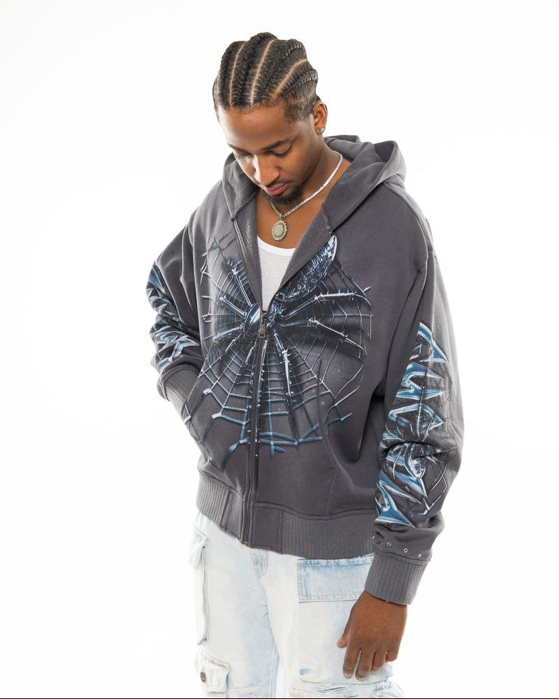 Man wearing a gray hoodie with a spider web design on a white background