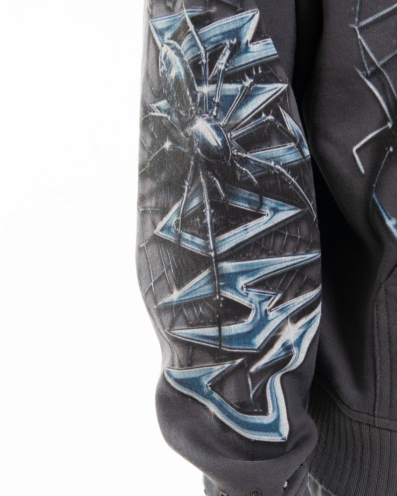 Close-up of a black jacket with blue geometric pattern on a white background