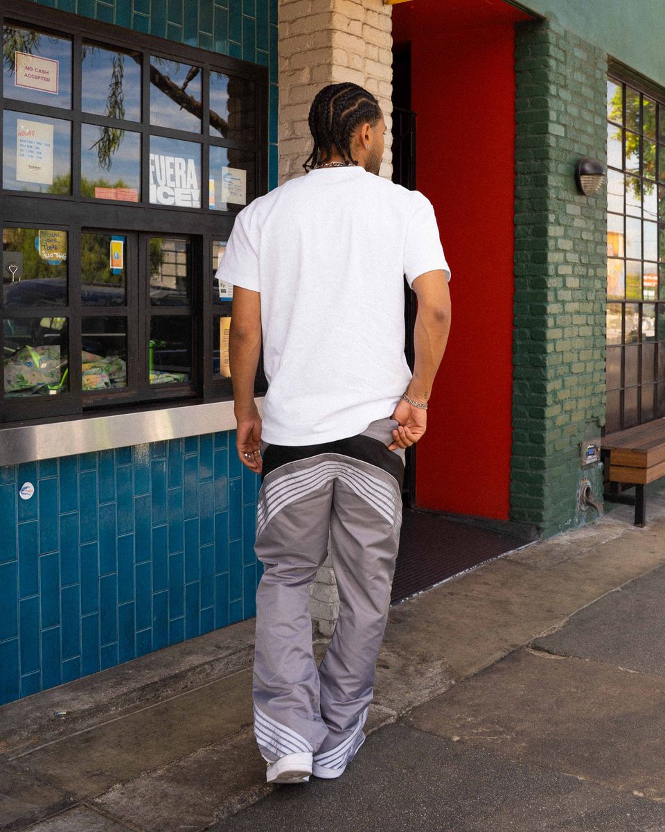 Person walking past a building with a red door and blue tiled wall.