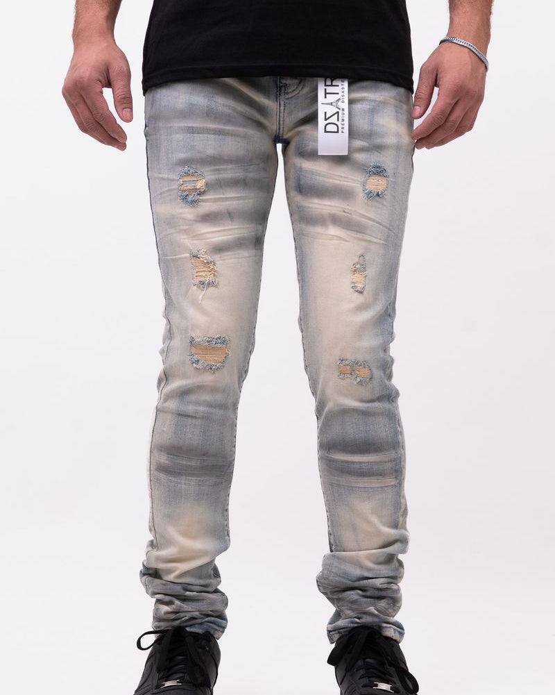 Person wearing distressed light blue jeans with a visible brand label on a white background