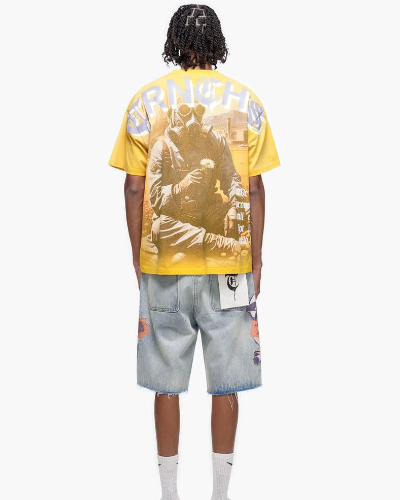 Person wearing a yellow graphic t-shirt and denim shorts on a white background