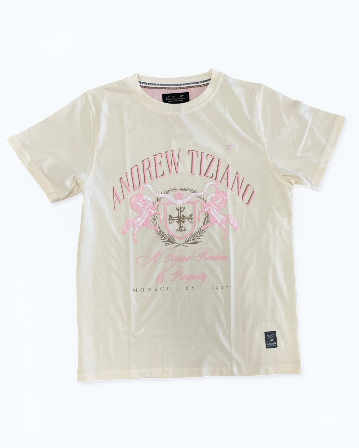 Cream t-shirt with 'Andrew Tiziano' logo and pink design on a white background