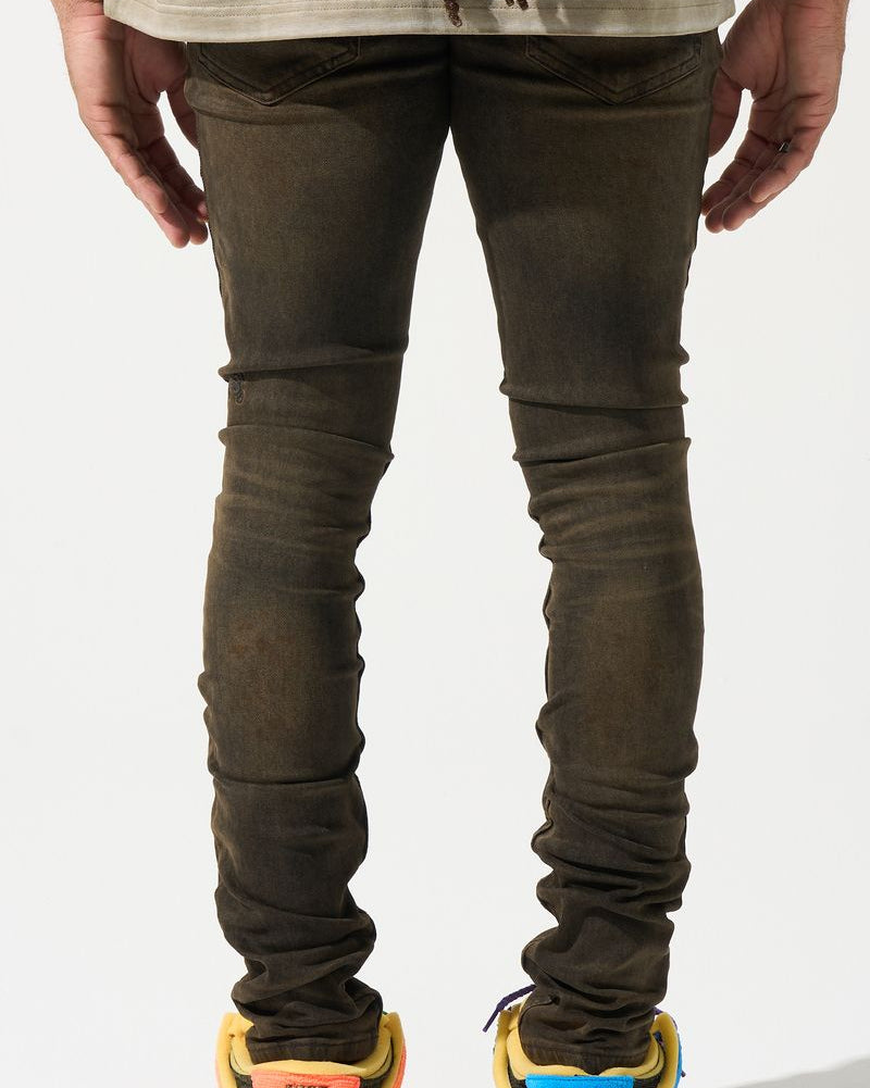 Person wearing dark jeans and multicolored sneakers on a white background