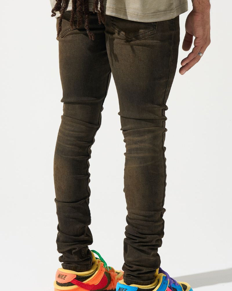 Person wearing dark jeans and colorful sneakers on a white background