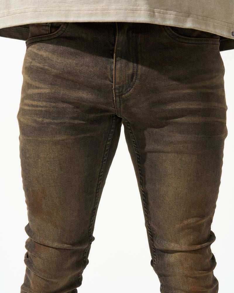 Brown distressed jeans worn by a person on a white background