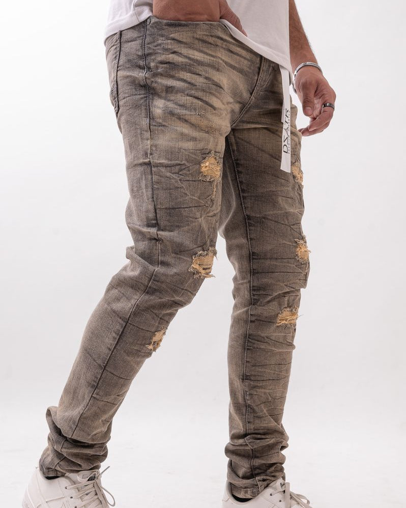 Person wearing distressed gray jeans and white sneakers on a white background