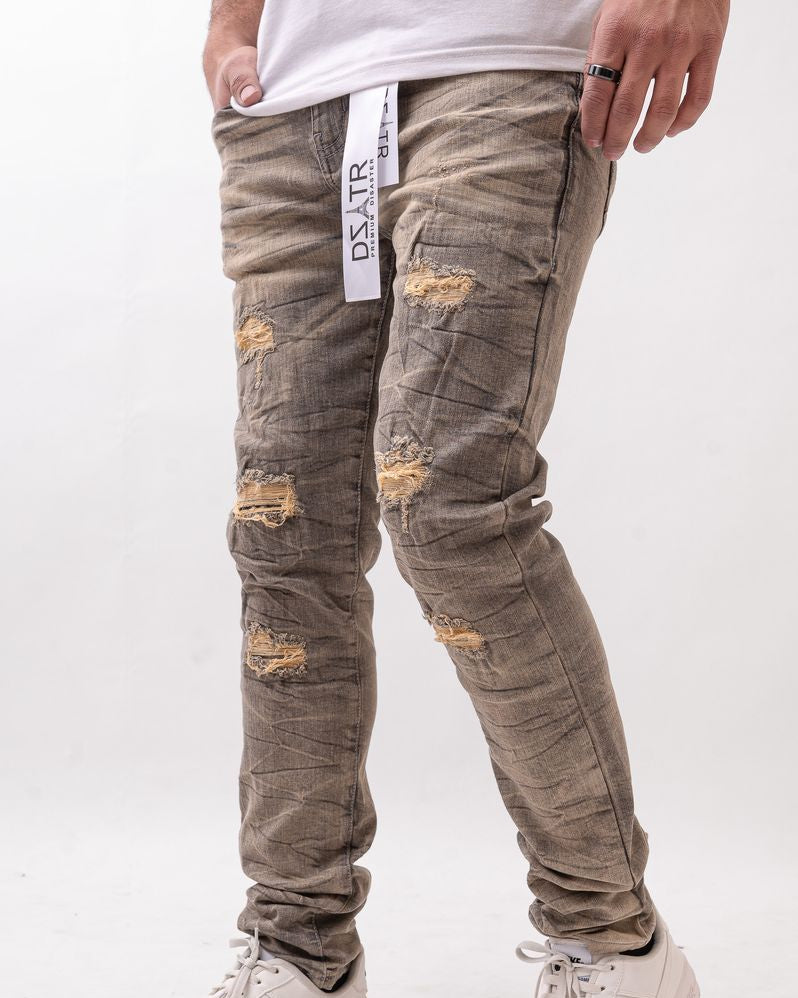 Person wearing distressed gray jeans with a white background