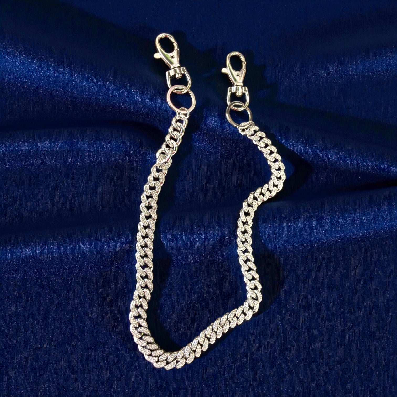 Silver chain with clasp on a blue satin background