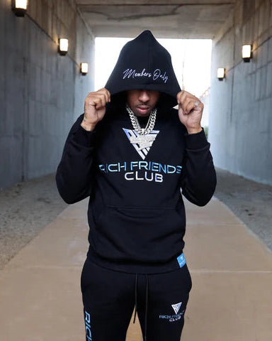 Person wearing a black hoodie with text in a tunnel.