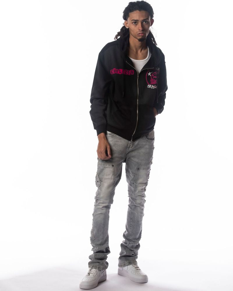 Person wearing a black hoodie with pink text and graphics, gray jeans, and white sneakers on a white background