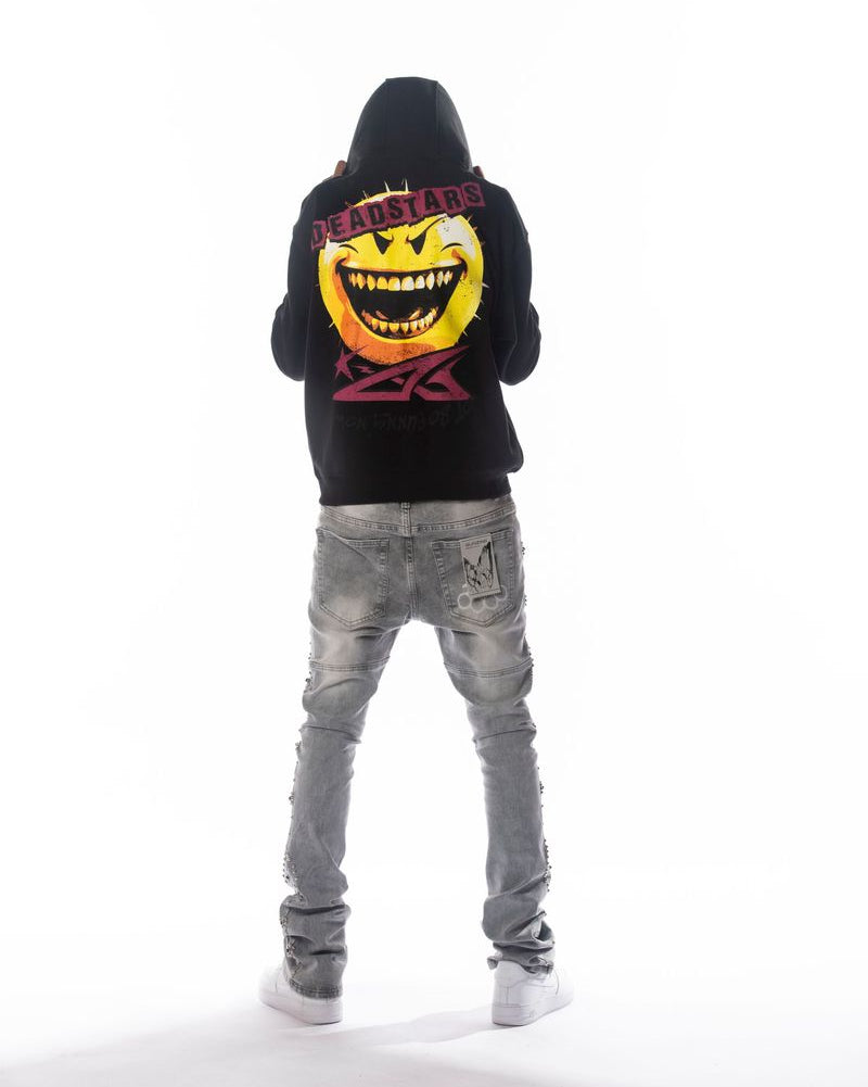 Person wearing a black hoodie with a colorful graphic on the back and gray jeans, standing against a white background.