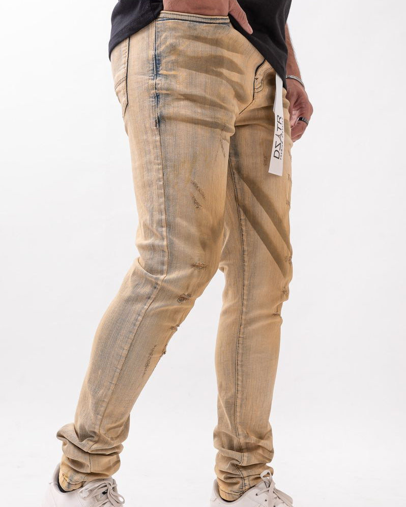 Beige distressed jeans worn by a person on a white background