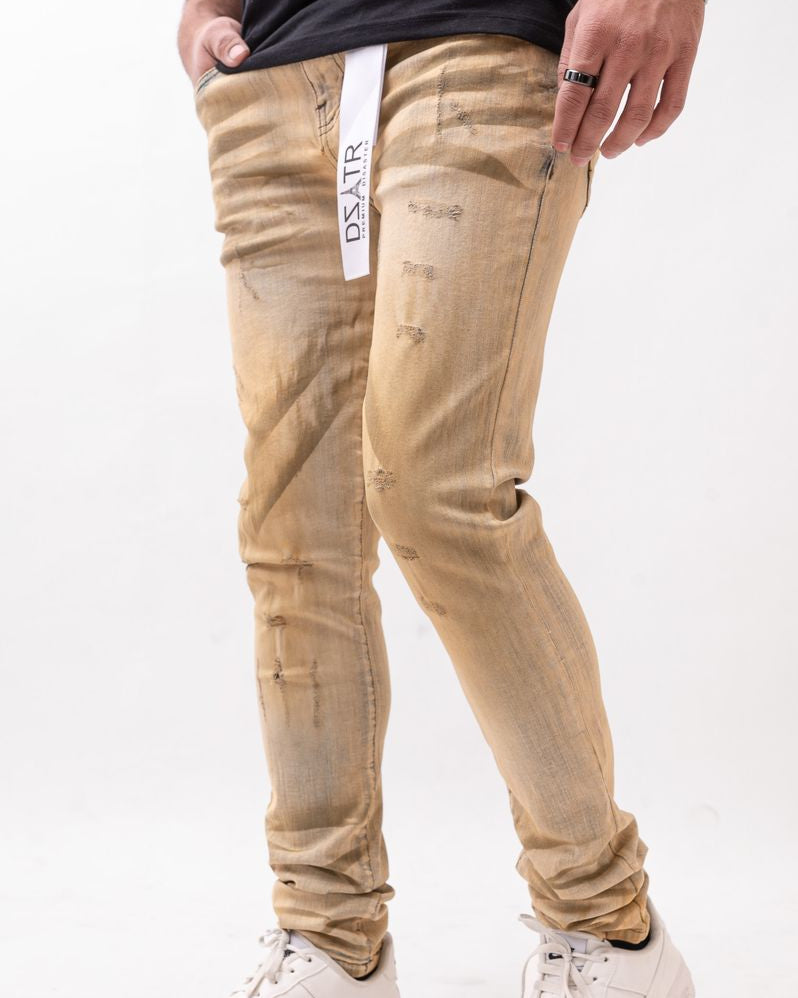 Beige distressed jeans worn by a person on a white background