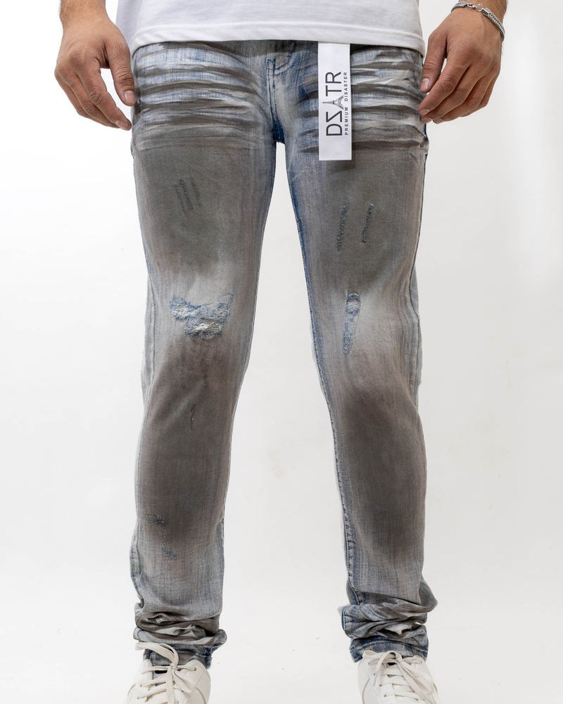Person wearing gray distressed jeans with a visible brand label on a white background