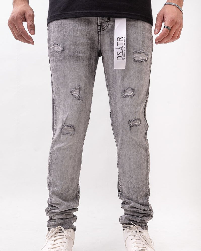 Person wearing gray distressed jeans with a brand label on a white background
