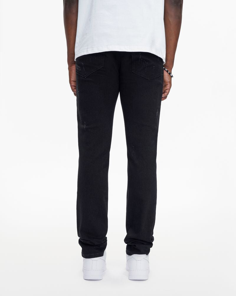 Person wearing black jeans and white shoes on a white background
