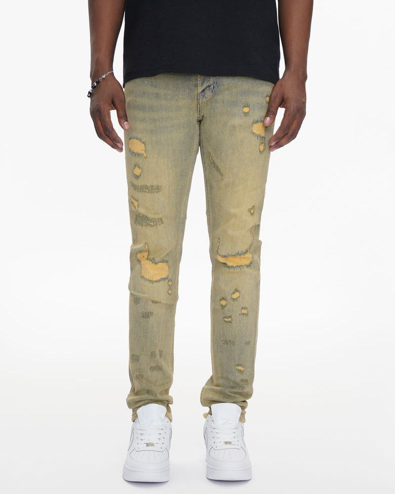 Person wearing distressed light green jeans and white sneakers on a white background