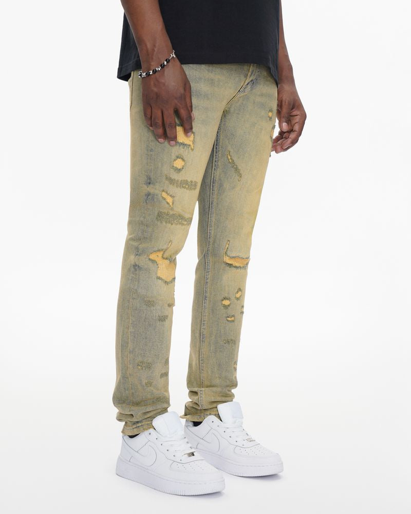 Person wearing light-colored distressed jeans and white sneakers on a white background