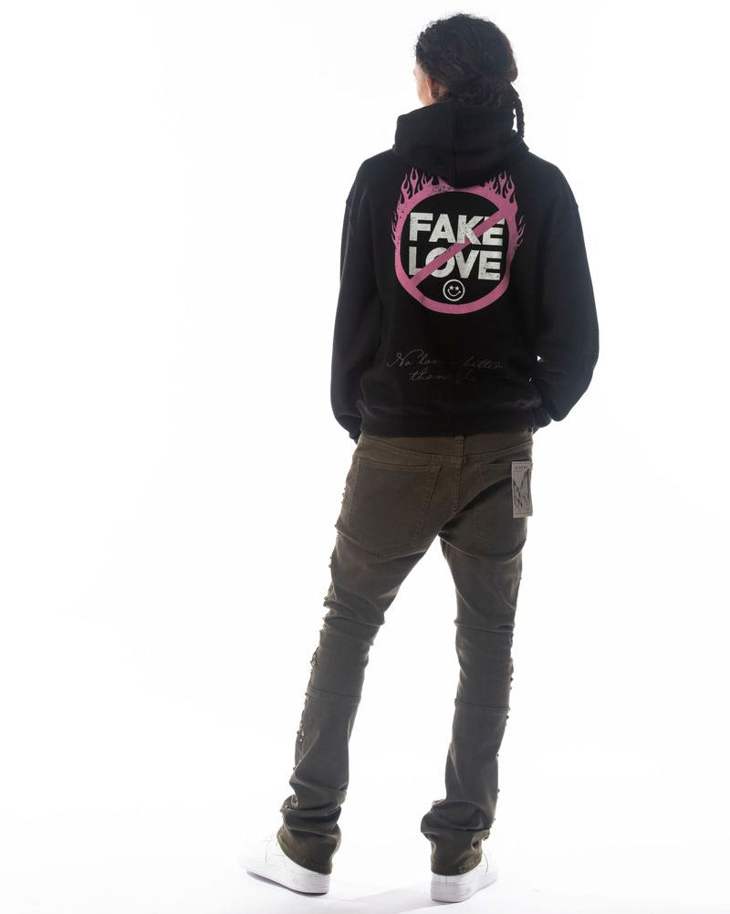 Person wearing a black hoodie with 'FAKE LOVE' text on the back, standing against a white background