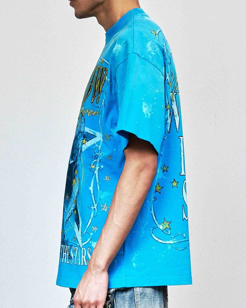 Person wearing a blue graphic t-shirt with star design on a plain background
