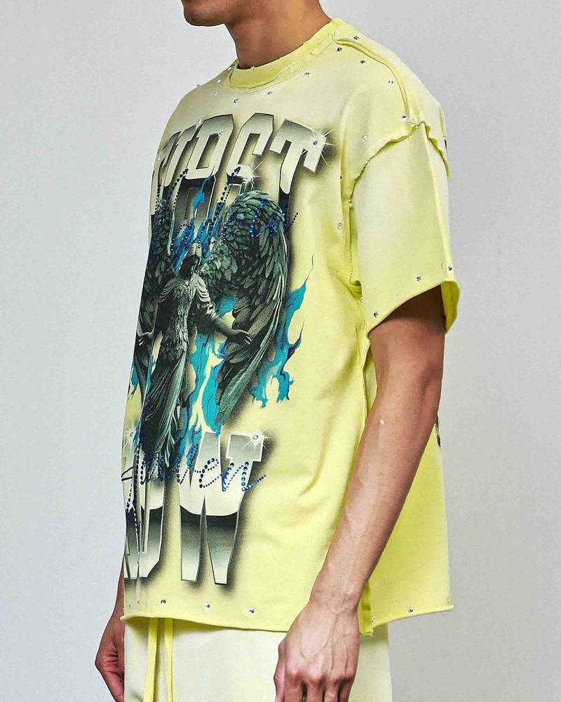 Person wearing a bright yellow t-shirt with graphic design on a plain background