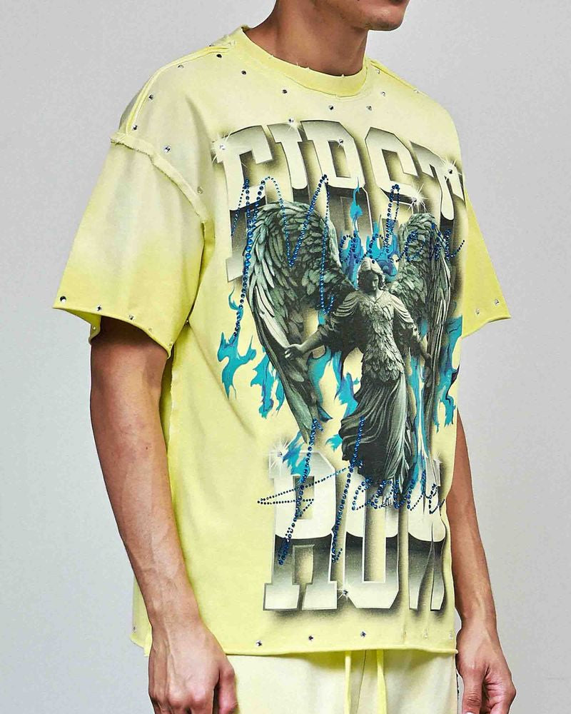 Person wearing a yellow graphic t-shirt with a design on a plain background