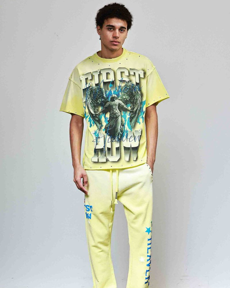 Person wearing a bright yellow graphic t-shirt and pants against a plain background