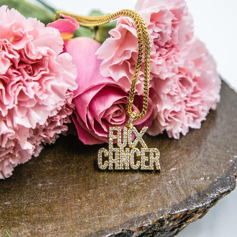 Gold necklace with 'F**K CANCER' pendant on pink flowers