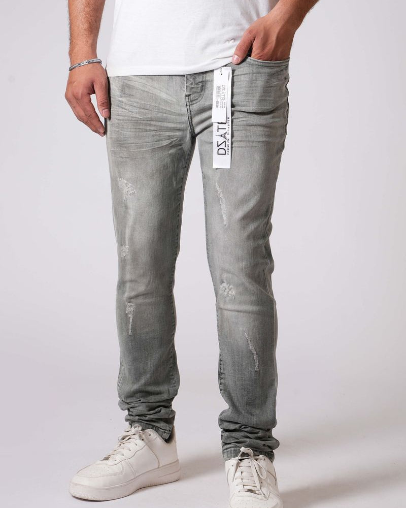 Person wearing gray distressed jeans with a visible brand label on a white background