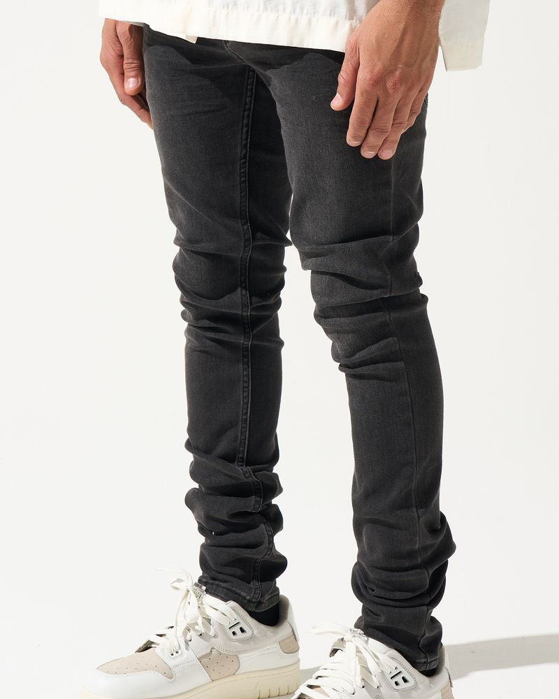 Person wearing black jeans and white sneakers on a white background