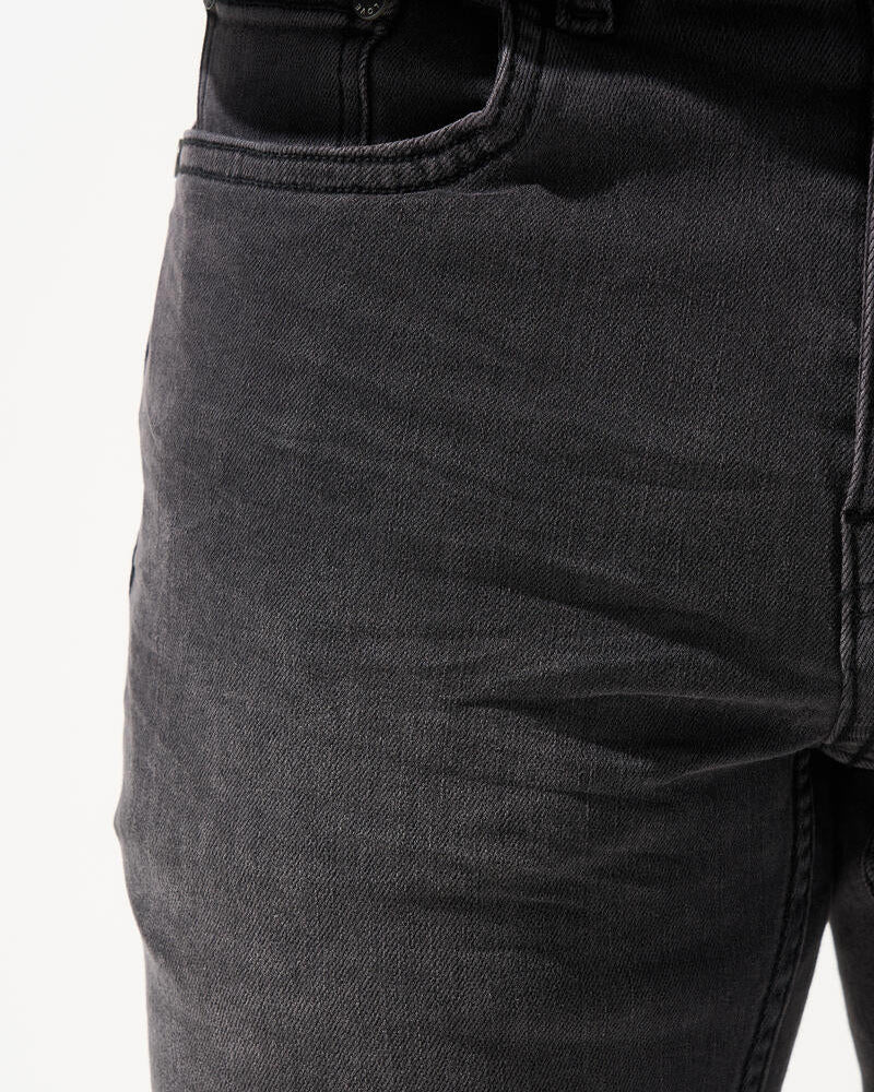 Close-up of dark gray jeans on a white background